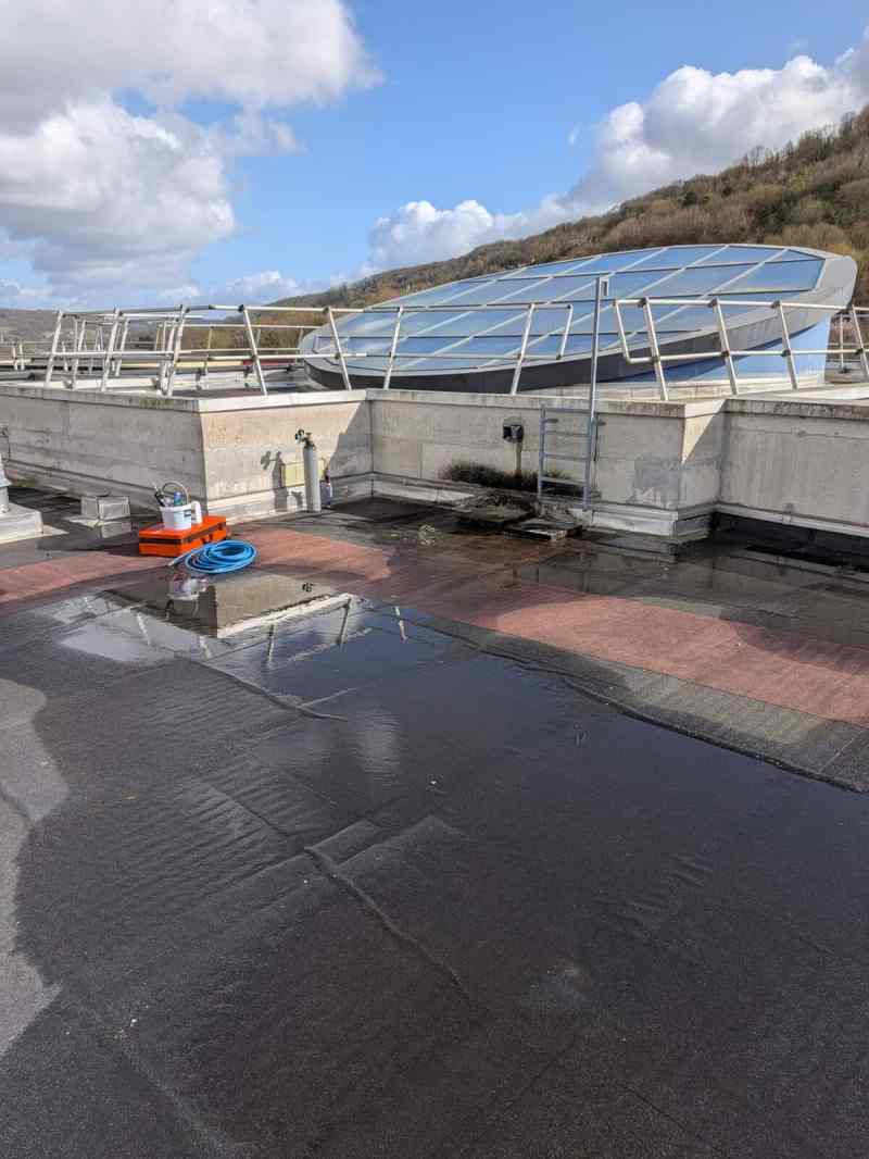 Toiture-terrasse mouillée avec flaques, avant une recherche de fuite